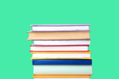 Yeşil arkaplan üzerine renkli kitap yığını