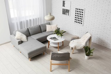 Oturma odasının içinde kanepe, sandalye, masa ve sansevieria bitkileri var.