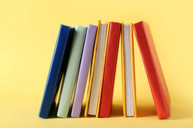 Sarı arkaplan üzerine birçok renkli kitap