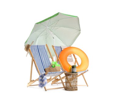 Yeşil plaj şemsiyeli çizgili güverte sandalyeleri ve beyaz arka planda izole edilmiş seyahat aksesuarları.