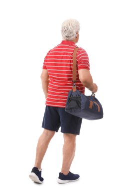 Spor çantalı son sınıf öğrencisi beyaz arka planda yürüyor.