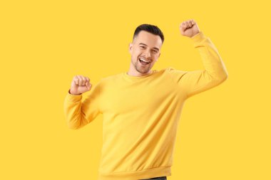 Sarı arka plandaki mutlu genç adam