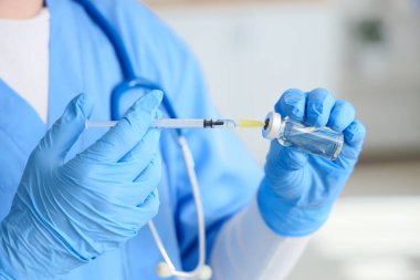 Klinikte aşı ve şırıngalı kadın doktor, yakın plan.