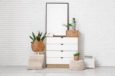 Klozet, boş çerçeve ve sepetlerde yeşil bitkiler olan odanın içi