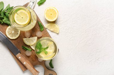 Beyaz arka planda naneli bir bardak taze limonata.