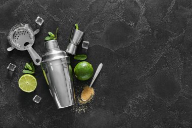 Titretici, süzgeç, ölçü kabı ve koyu arkaplanda mojito hazırlamak için malzemeler