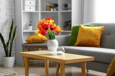 Oturma odasındaki sehpanın üstünde güzel lale çiçekleri olan vazo.