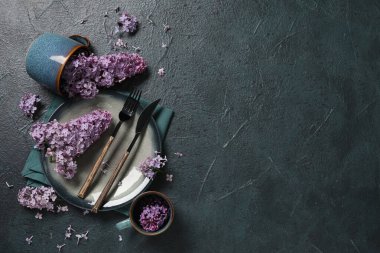 Koyu arkaplanda leylak çiçekleri olan güzel bir masa.