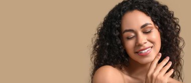 Güzel mutlu Afro-Amerikalı kadın bej arka planda sağlıklı tenli ve mesaj için yeri olan