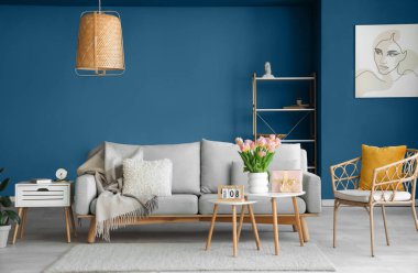 Uluslararası Kadınlar Günü için hediye kutusu ve laleleri olan oturma odasının masalarında.