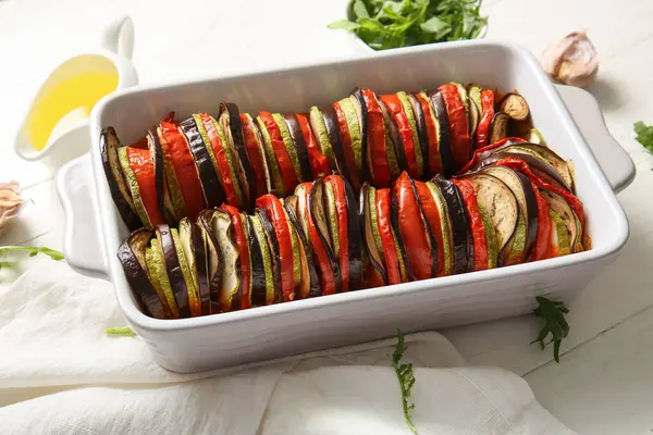 Beyaz ahşap arka planda lezzetli Ratatouille yemeği pişirmek.