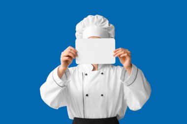 Kadın aşçı mavi arka planda boş bir kart tutuyor.
