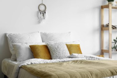 Yatak odası, raflar ve beyaz duvarda asılı düş kapanı olan modern yatak odası.