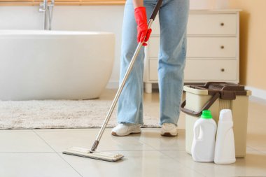 Banyoda paspas yapan genç bir kadın.