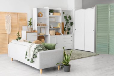 Dolabı, kanepesi ve katlanır perdesi olan oturma odasının içinde.