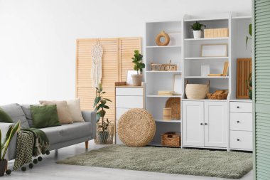 Dolabı, kanepesi ve katlanır perdesi olan oturma odasının içinde.