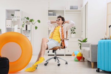 Paletli genç işadamı yaz tatilini ofiste bekliyor.