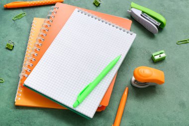 Boş defter ve grunge yeşil arkaplan üzerindeki farklı kırtasiye