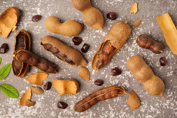 Gri arka planda lezzetli tamarinler ve tohumlar