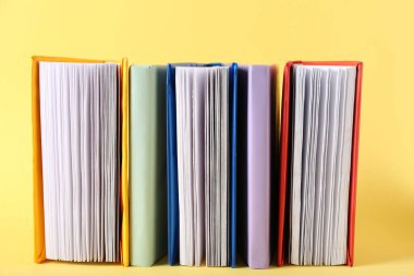 Sarı arkaplan üzerine renkli kitaplar dizisi