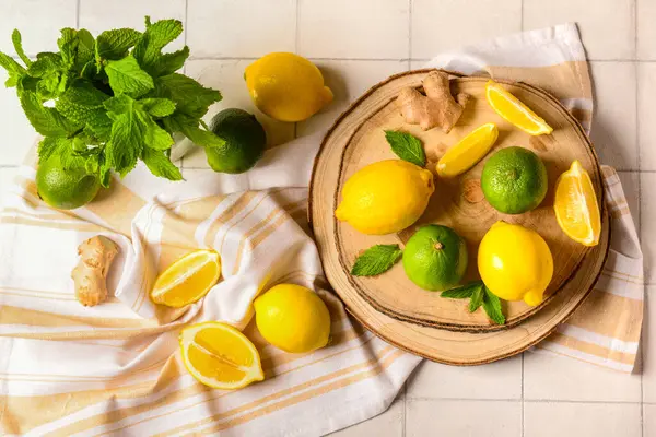 Beyaz fayans zemininde limonata hazırlamak için malzemeler içeren ahşap tahta tahta.