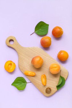 Taze kayısıları ve leylak arkaplanda yaprakları olan tahta