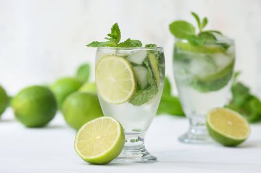 Beyaz arka planda taze mojito kokteyli ve nane şekeri.