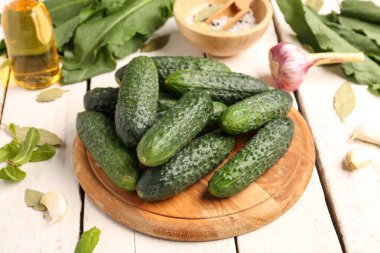 Hafif ahşap arka planda taze salatalık korunması için kurulmuş.