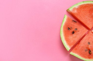 Pembe arka planda olgun karpuz parçaları olan kompozisyon, yakın plan.