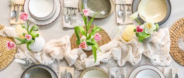 Lokantada güzel lale çiçekleri, mumlar ve temiz tabaklar olan şık bir masa.