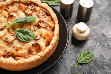 Ispanak yapraklı mantar turtası ve koyu gri grunge arka planda şampiyonlar.