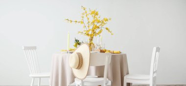 Yanan mumlar, bardaklar ve çiçek açan ağaç dalları olan zarif bir masa.