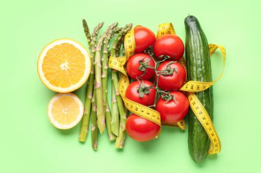 Sebzeler, yeşil arka planda limon ve sarı mezura. Diyet kavramı
