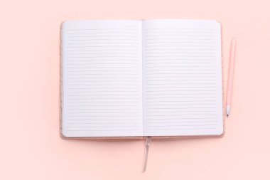 Pembe zemin üzerinde kalem olan boş bir defter aç