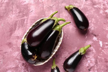 Pembe arka planda taze patlıcan sepeti.