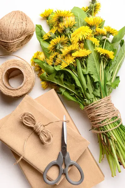 Güzel karahindiba çiçekleri, halat, makas ve ışık arkaplan üzerine kitaplar, yakın plan