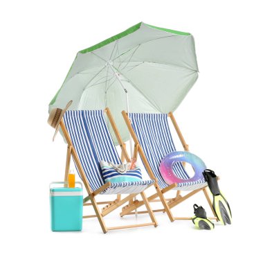 Yeşil plaj şemsiyeli çizgili güverte sandalyeleri ve beyaz arka planda izole edilmiş seyahat aksesuarları.