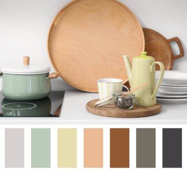 Mutfakta yeşil çaydanlık, fincan ve kuru çay. Farklı renk desenleri