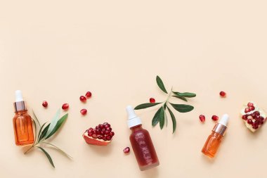 Renkli arka planda gerekli yağ, nar ve bitki dallarından oluşan şişelerle bileşim