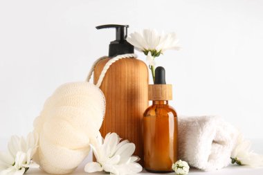 Banyo malzemeleri ve beyaz arka planda papatya çiçekleri olan kompozisyon