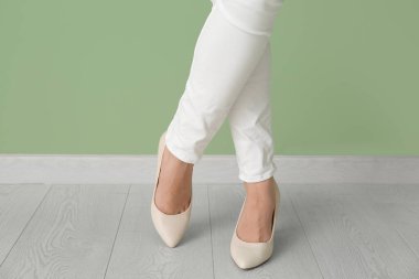 Renkli duvarın yanında duran şık ayakkabılı kadın, yakın plan.