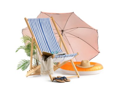 Plaj şemsiyeli çizgili güverte sandalyesi ve beyaz arka planda izole edilmiş seyahat aksesuarları.