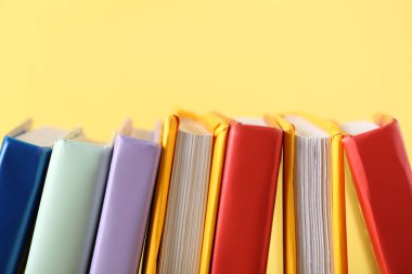 Sarı arkaplan üzerine birçok renkli kitap, yakın plan