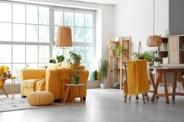 Sarı kanepeli ve çiçekli modern oturma odasının içi.