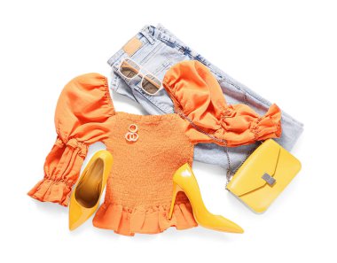 Beyaz arka planda takıları ve aksesuarları olan şık bir kadın bahar elbisesi.