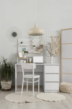 Çalışma yeri, tahta ve vazolarda çiçek açan dallarla aydınlık ofisin içinde.