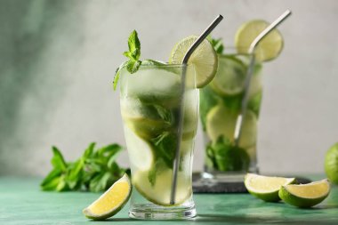 Yeşil masada limonlu ve naneli taze mojito kokteyli.