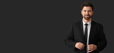 Siyah arka planda şık takım elbiseli yakışıklı bir adam ve metin için yeri var.