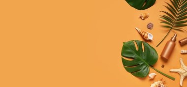 Turuncu zemin üzerinde güneş kremi, deniz kabukları ve tropikal yapraklar bulunan yaz kompozisyonu.