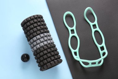 Dalga germe halkası ve mavi arka planda yoga minderi olan köpük silindirli.